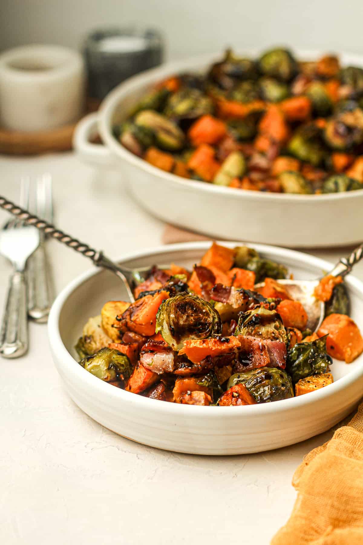 Side view of a plate of brussels sprouts and sweet potatoes.