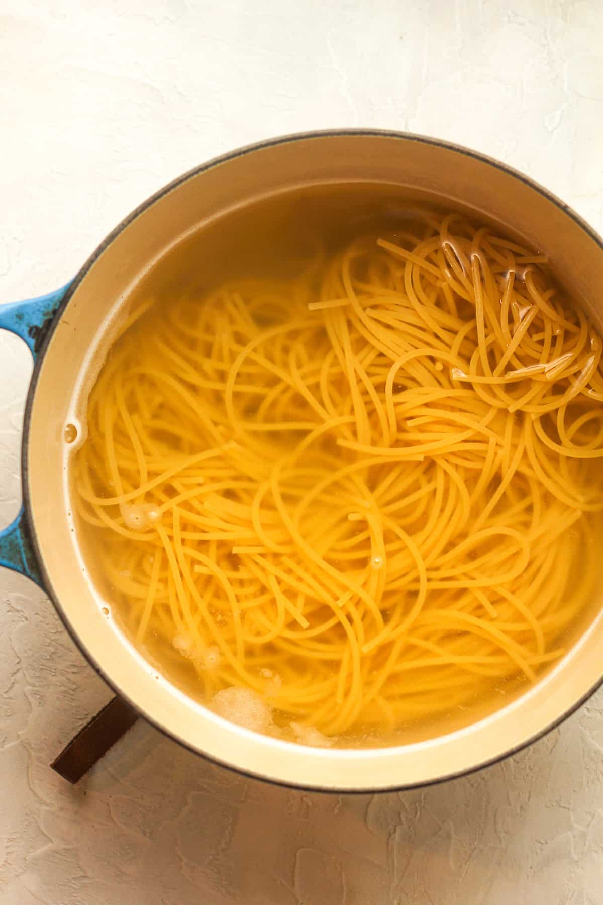 A pot of boiled spaghetti noodles.