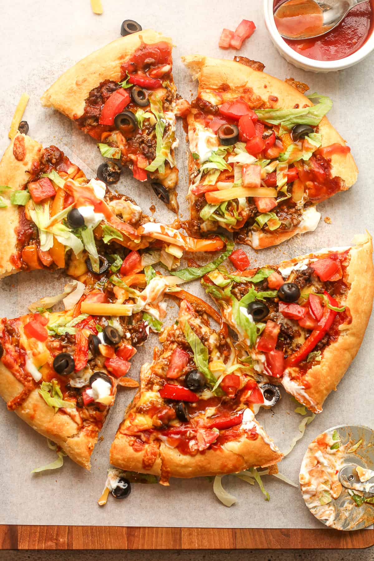 Overhead view of a sliced Godfather's pizza with taco sauce on top.