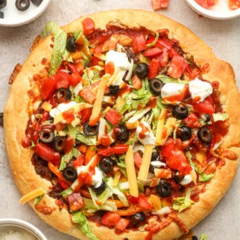 A taco pizza with toppings added on top.