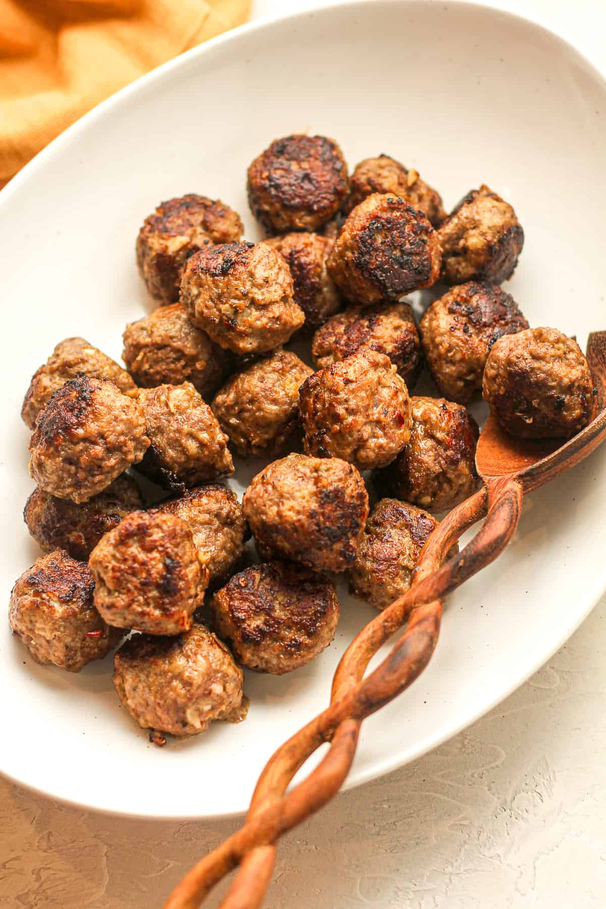 A oval platter of just cooked pork and beef meatballs.