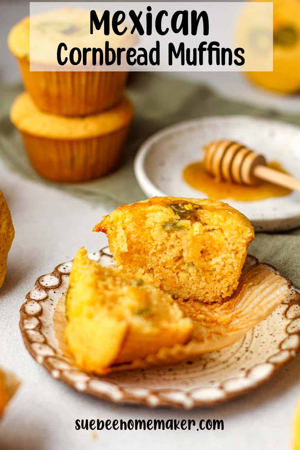 Side view of a small plate of a halved cornbread muffin with cheese and jalapeno.