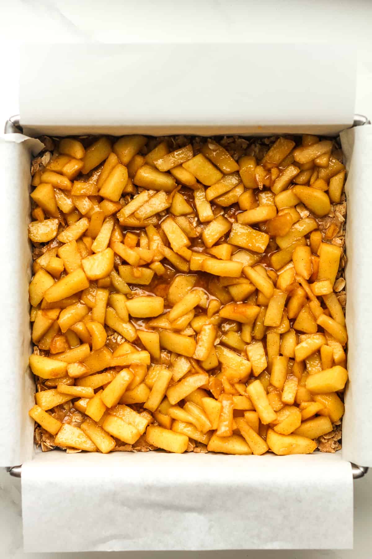 A square pan of the apple bars with the cooked apples on top.