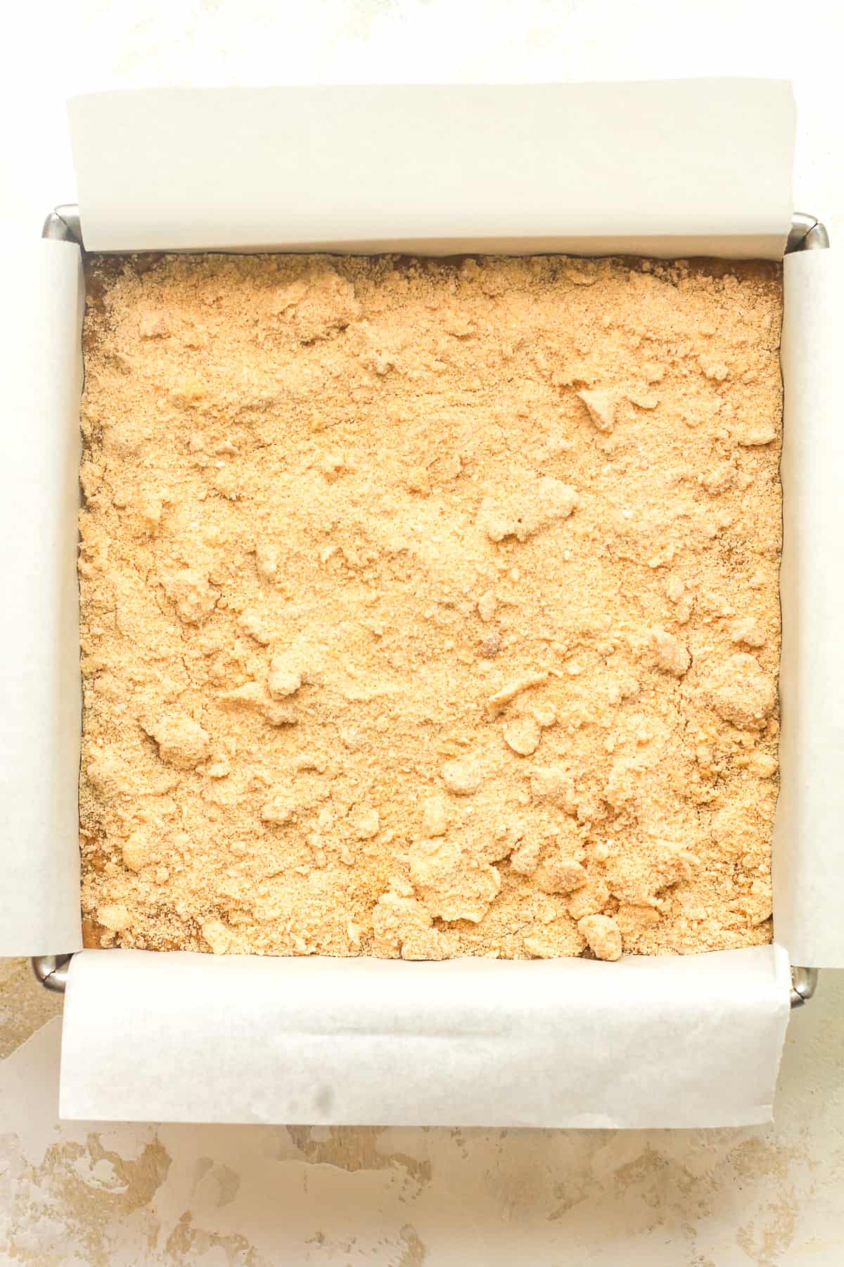 A square pan of the cake batter plus streusel on top.