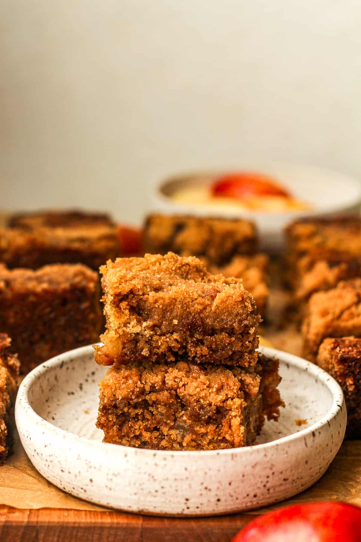 Side view of two stacked apple streusel cake squares on a board.