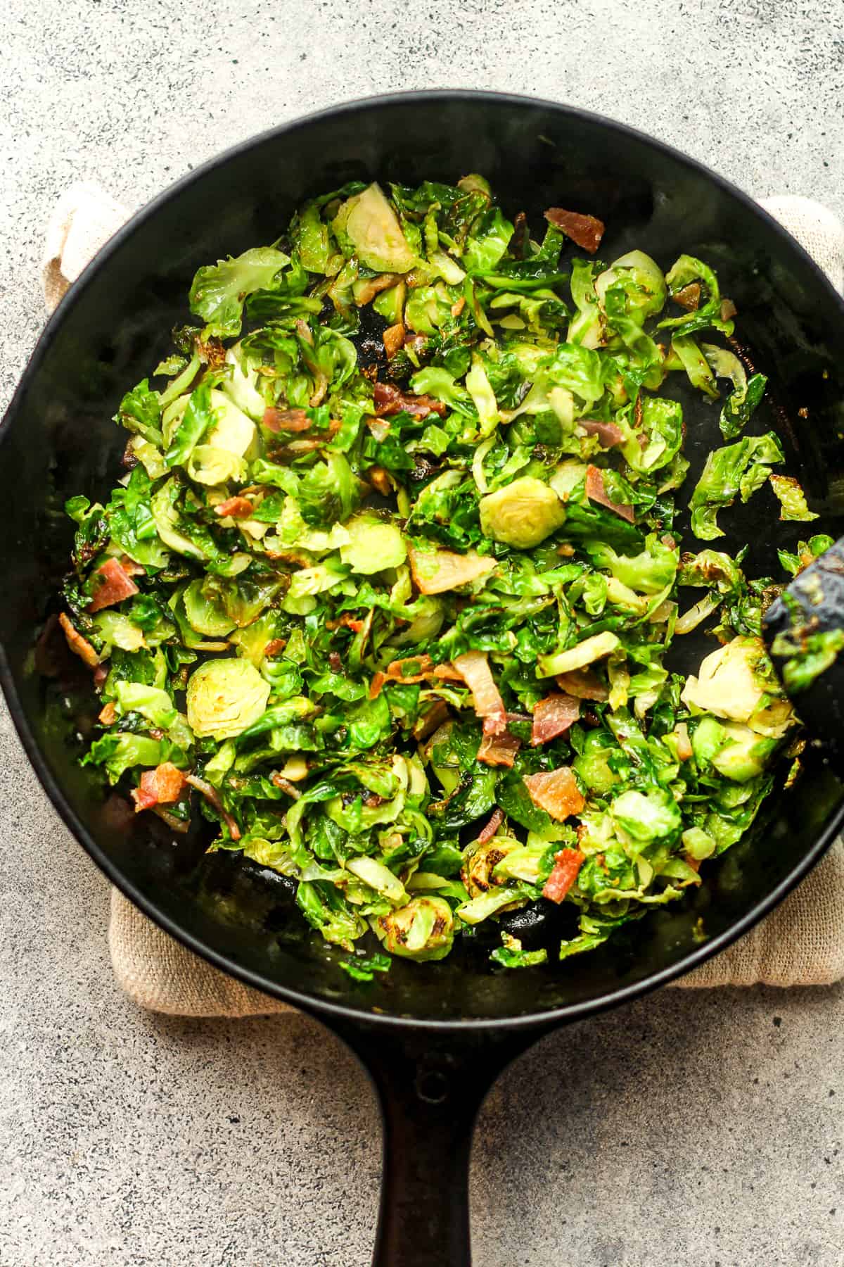 A skillet of sautéed Brussels Sprouts with bacon.