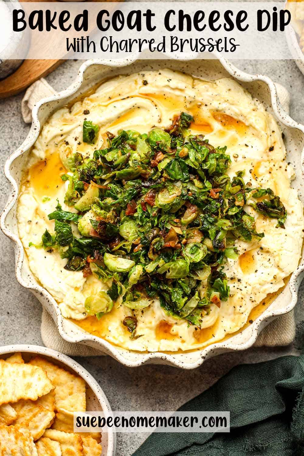 A pie plate of baked goat cheese dip with charred brussels.