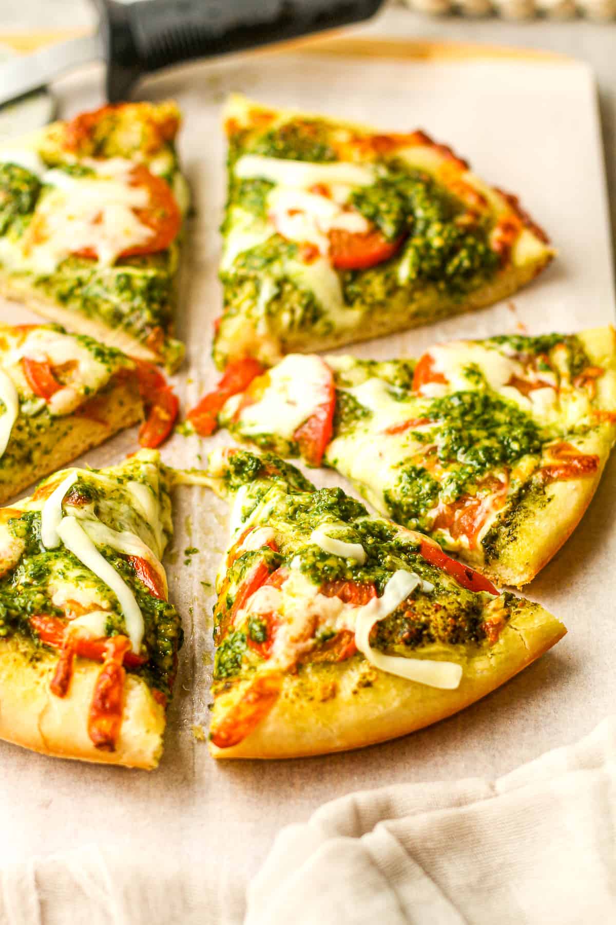 Side view of some slices of pesto pizza.