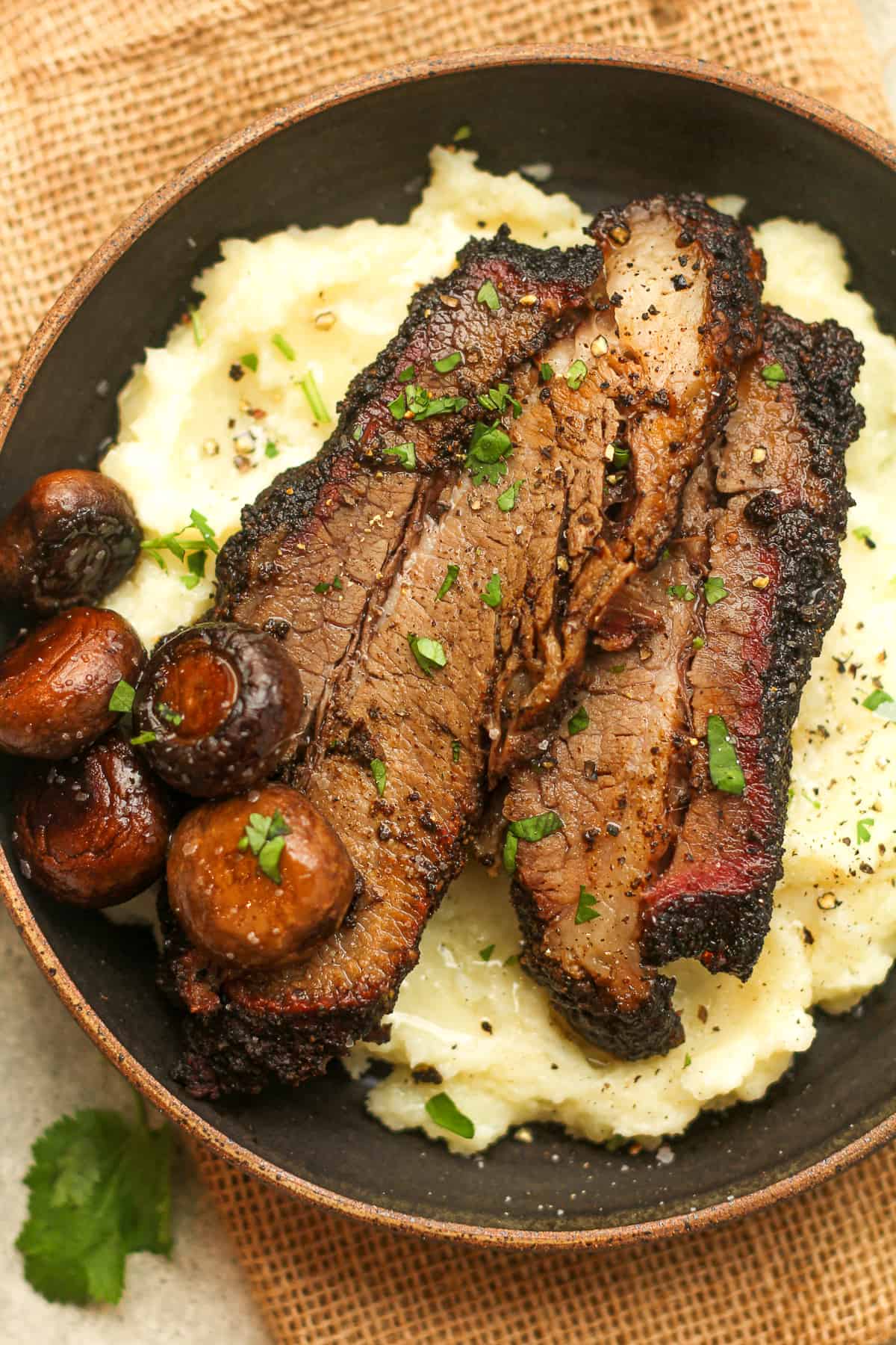 Closeup on a bowl of potatoes and smoked beef brisket.