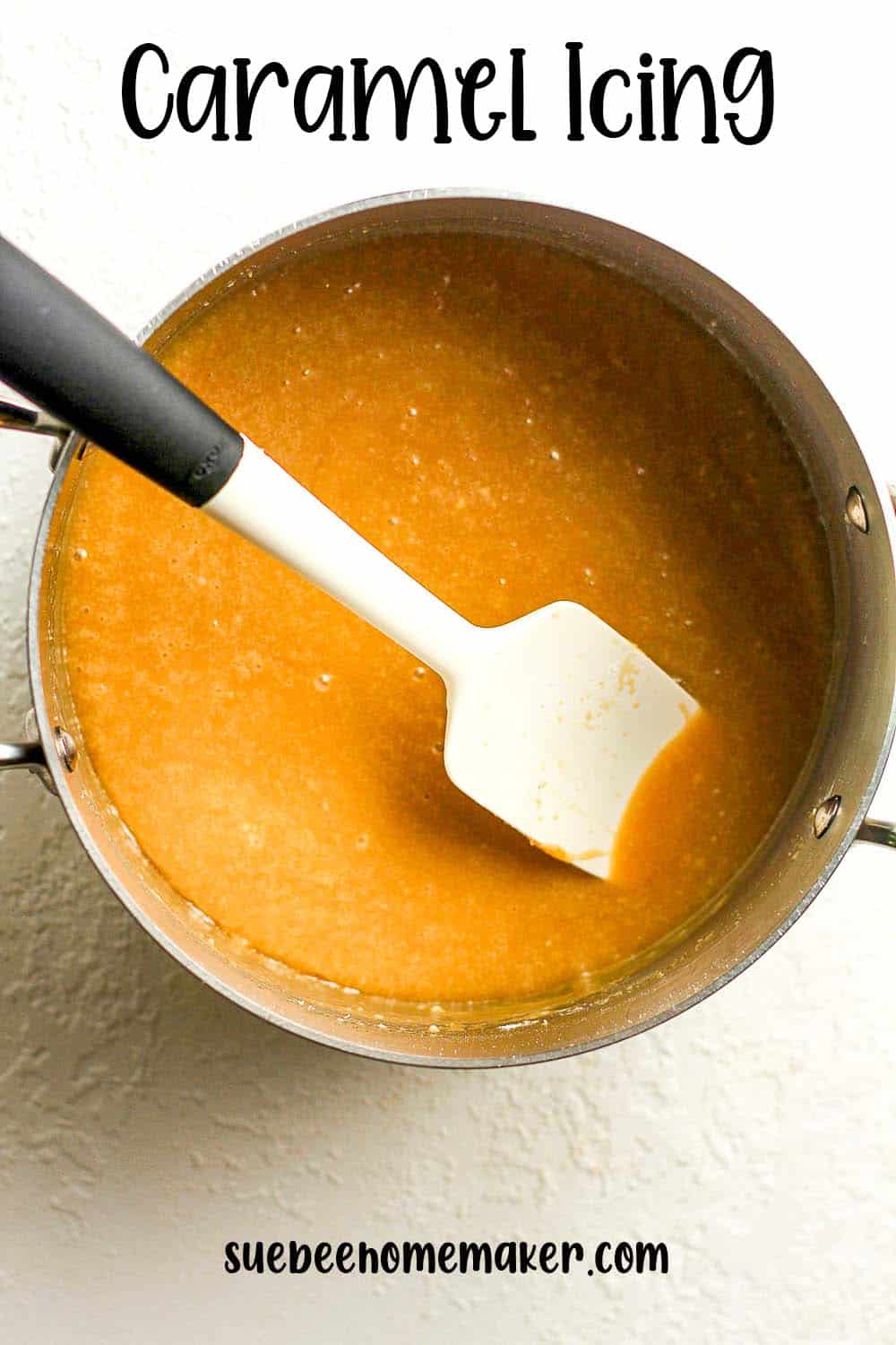A pan of caramel icing with a spatula.