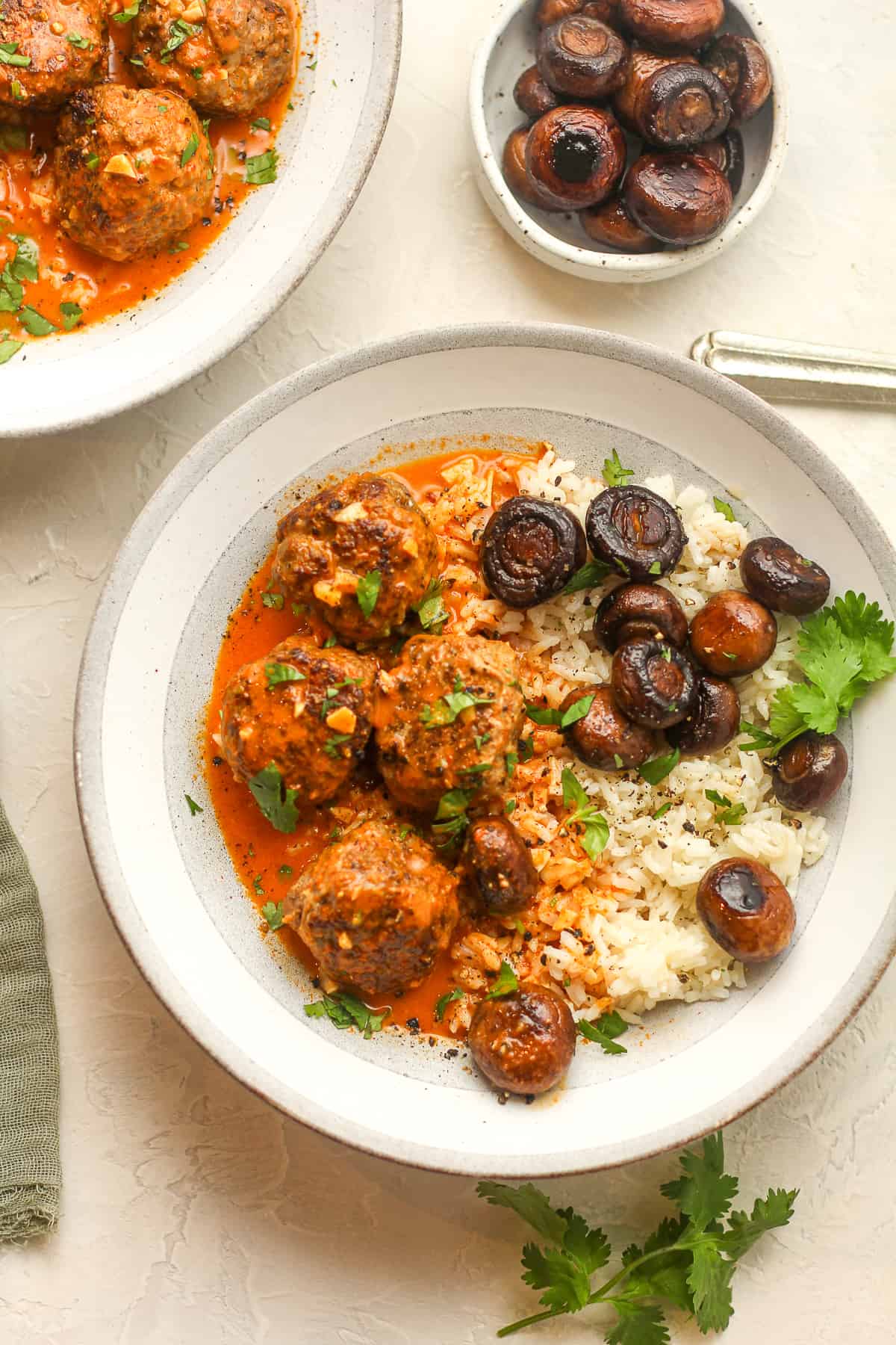 Two bowls of curried meatballs over rice.