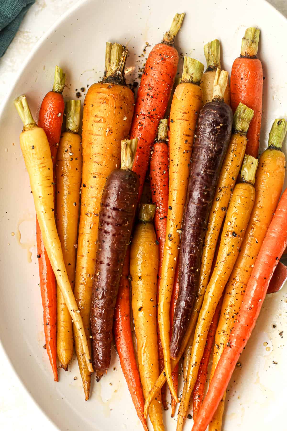 A closeup on some maple roasted carrots in a serving bowl.