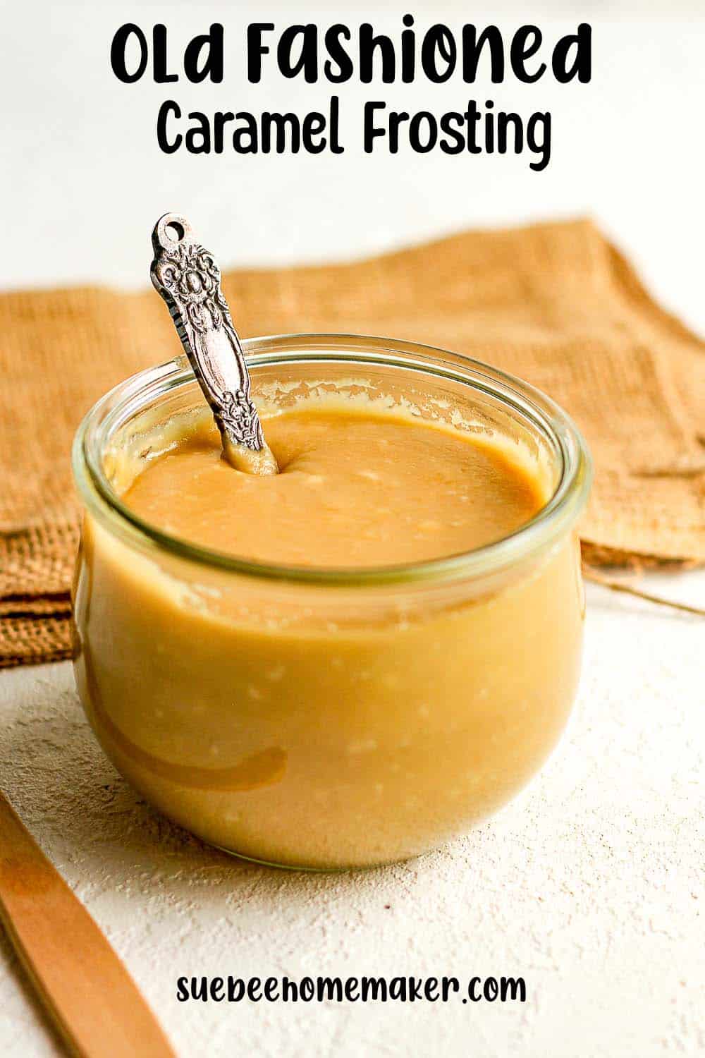 A jar of old fashioned caramel frosting with a spoon inside the jar.
