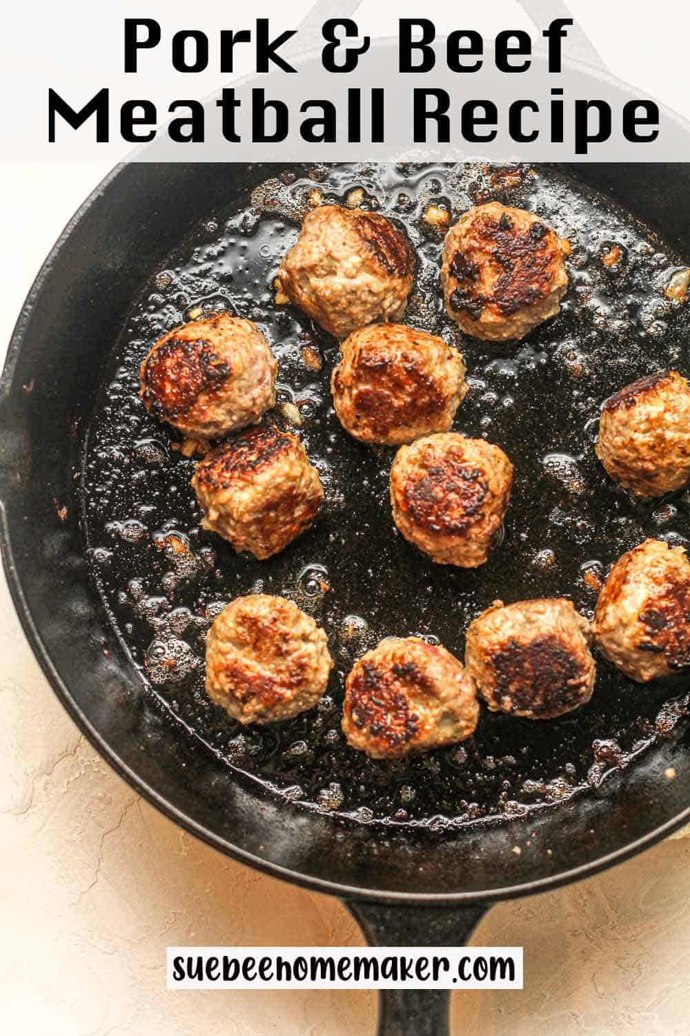 A cast iron skillet of browned pork and beef meatballs.