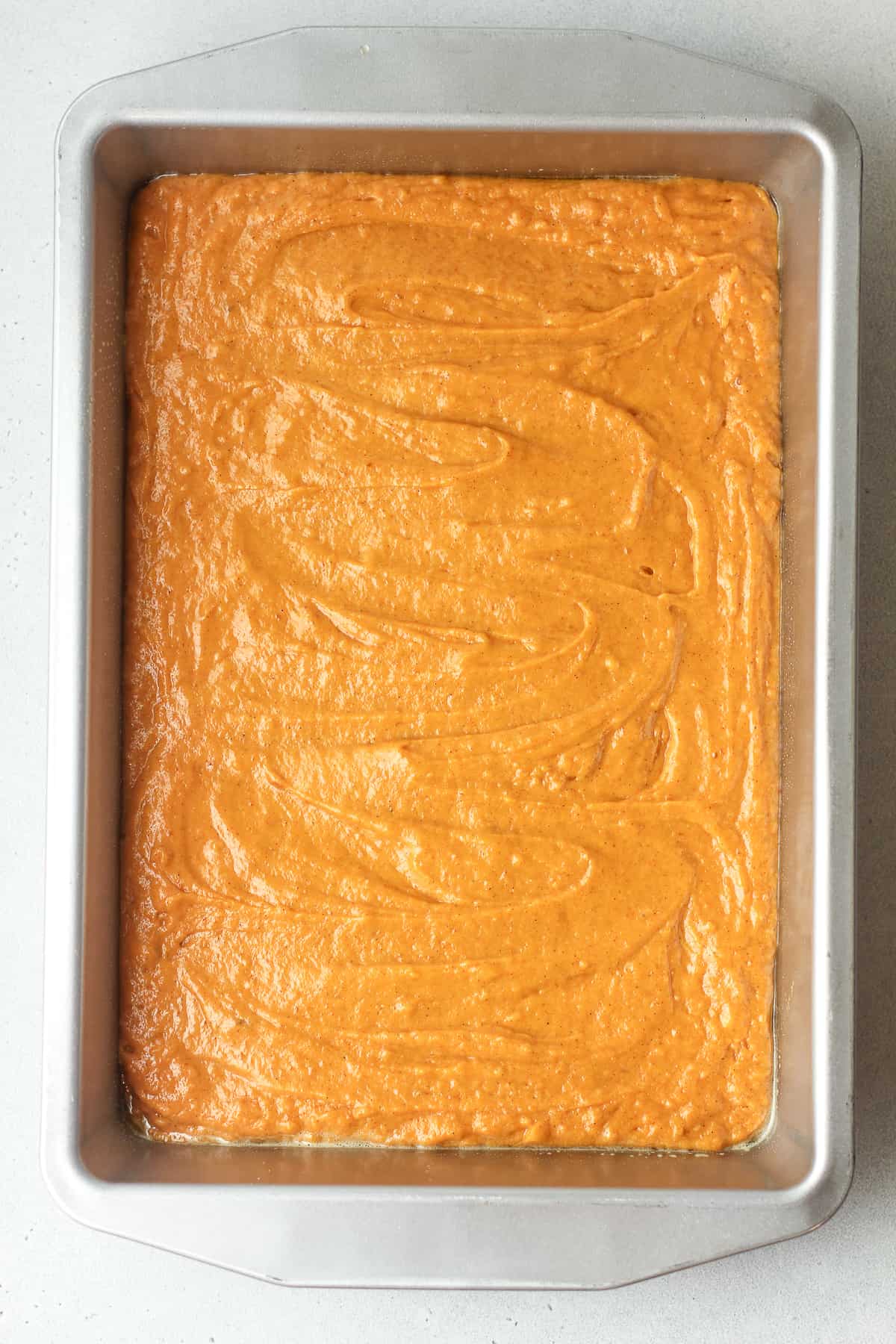 The pumpkin cake batter in a rectangular pan.