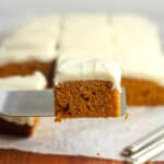 A closeup of a piece of pumpkin cake with cream cheese frosting.
