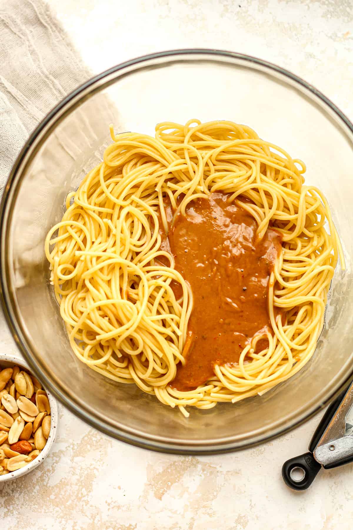 A bowl of spaghetti noodles and peanut sauce.