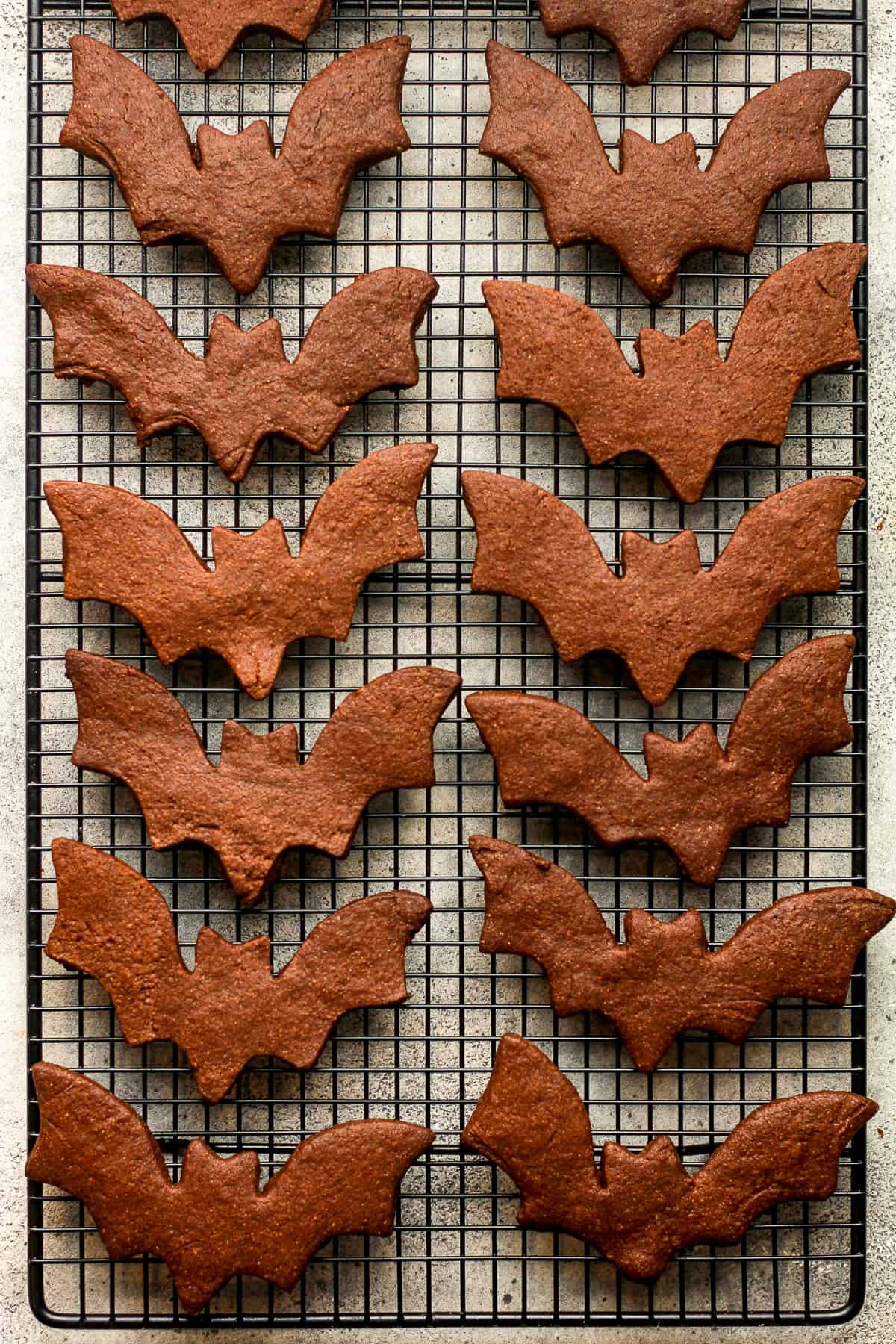 A wire rack with the bat cut-out cookies.