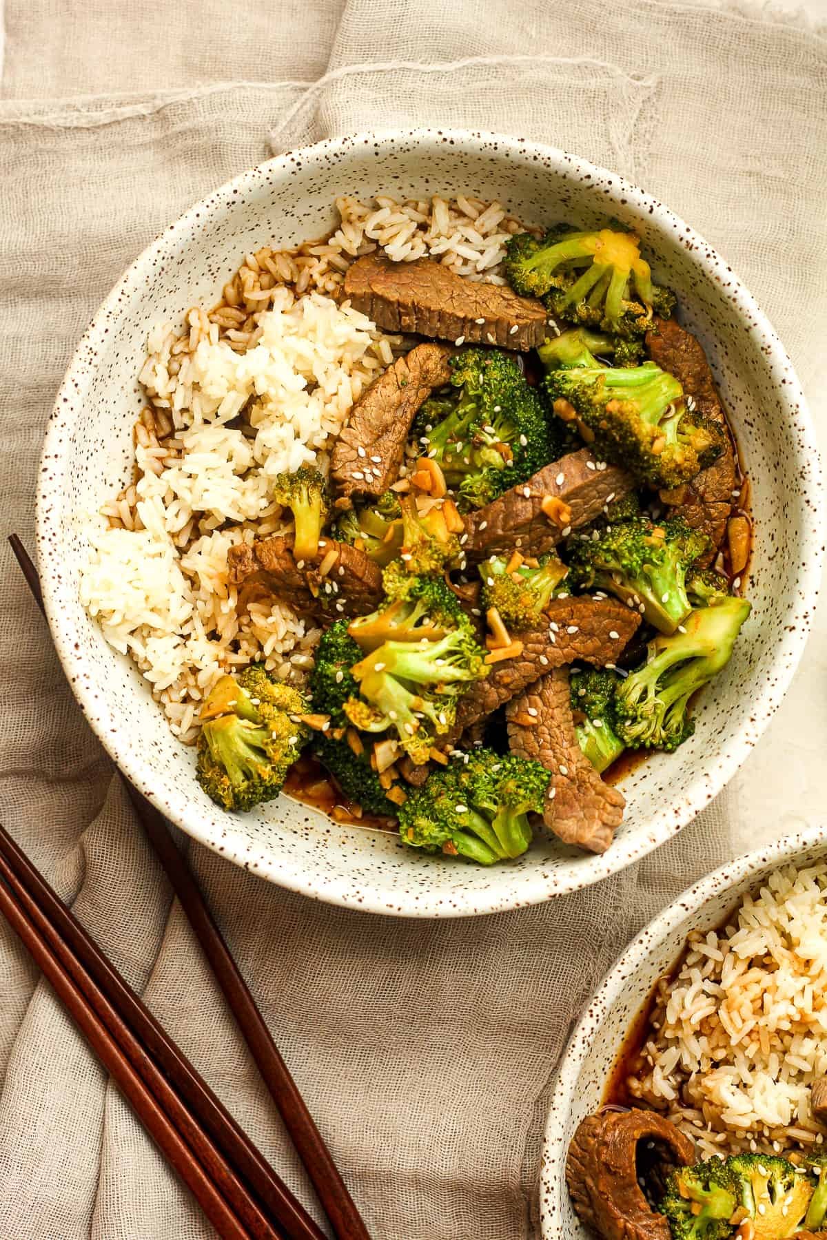 Two bowls of beef and broccoli stir fry over rice.
