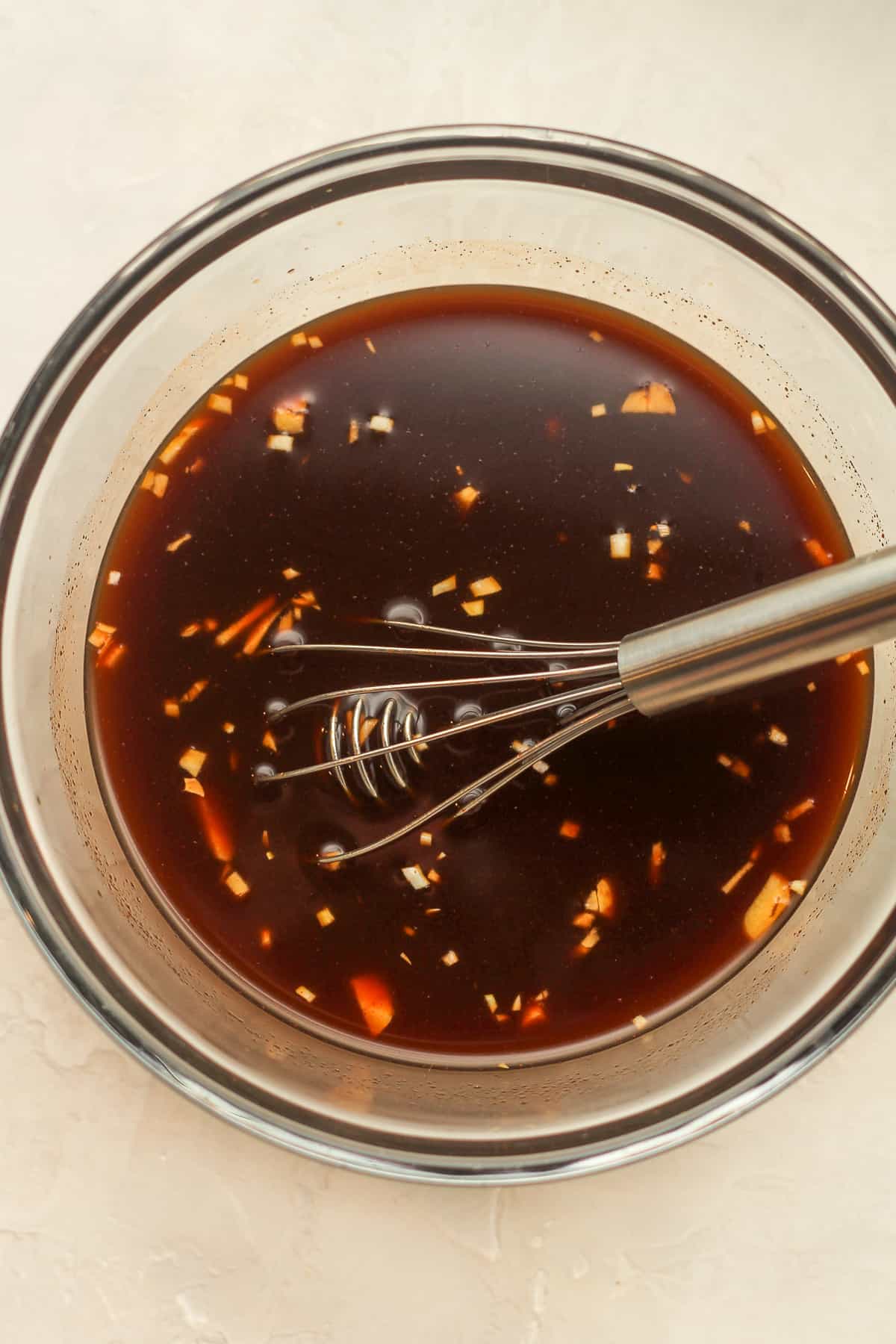 A bowl of the Asian sauce with a whisk.