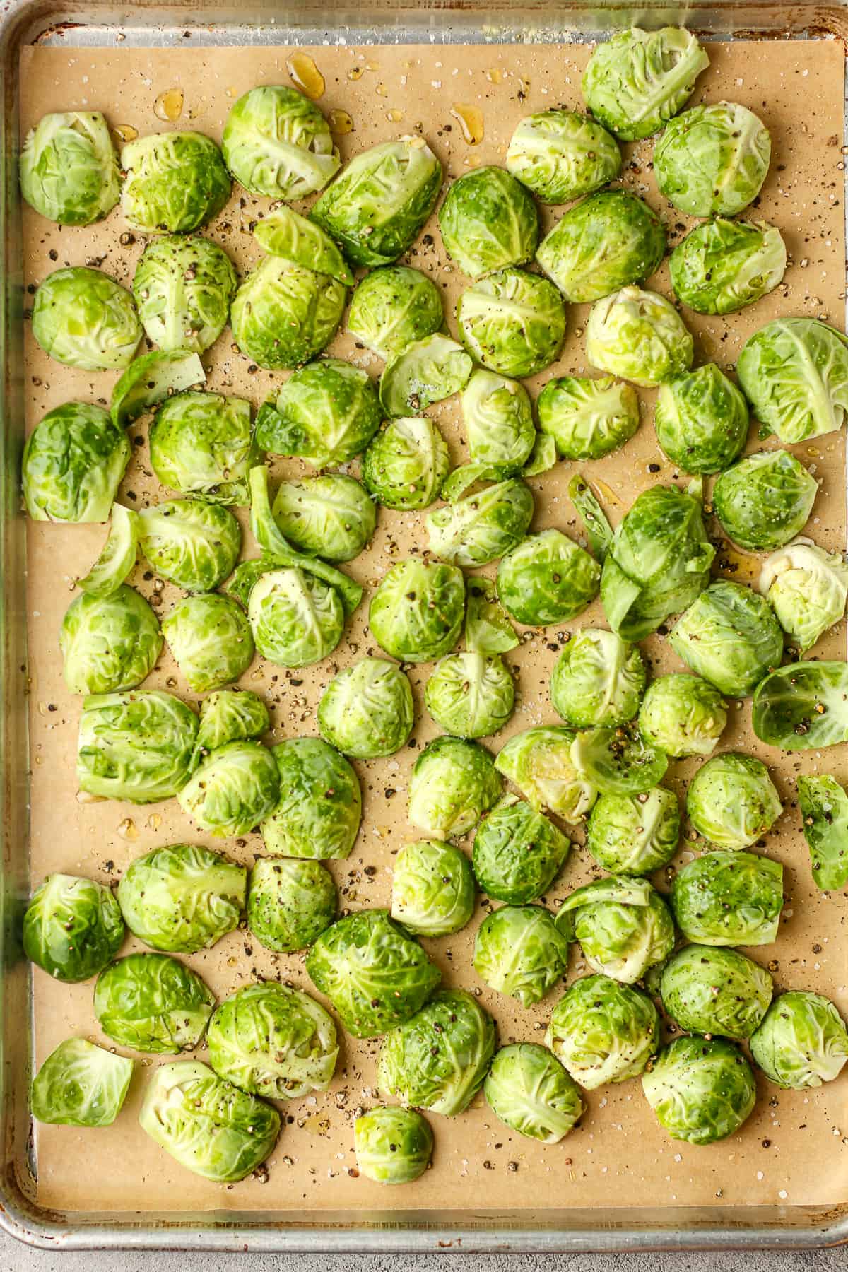 A pan of halved brussels sprouts with olive oil, salt, and pepper.