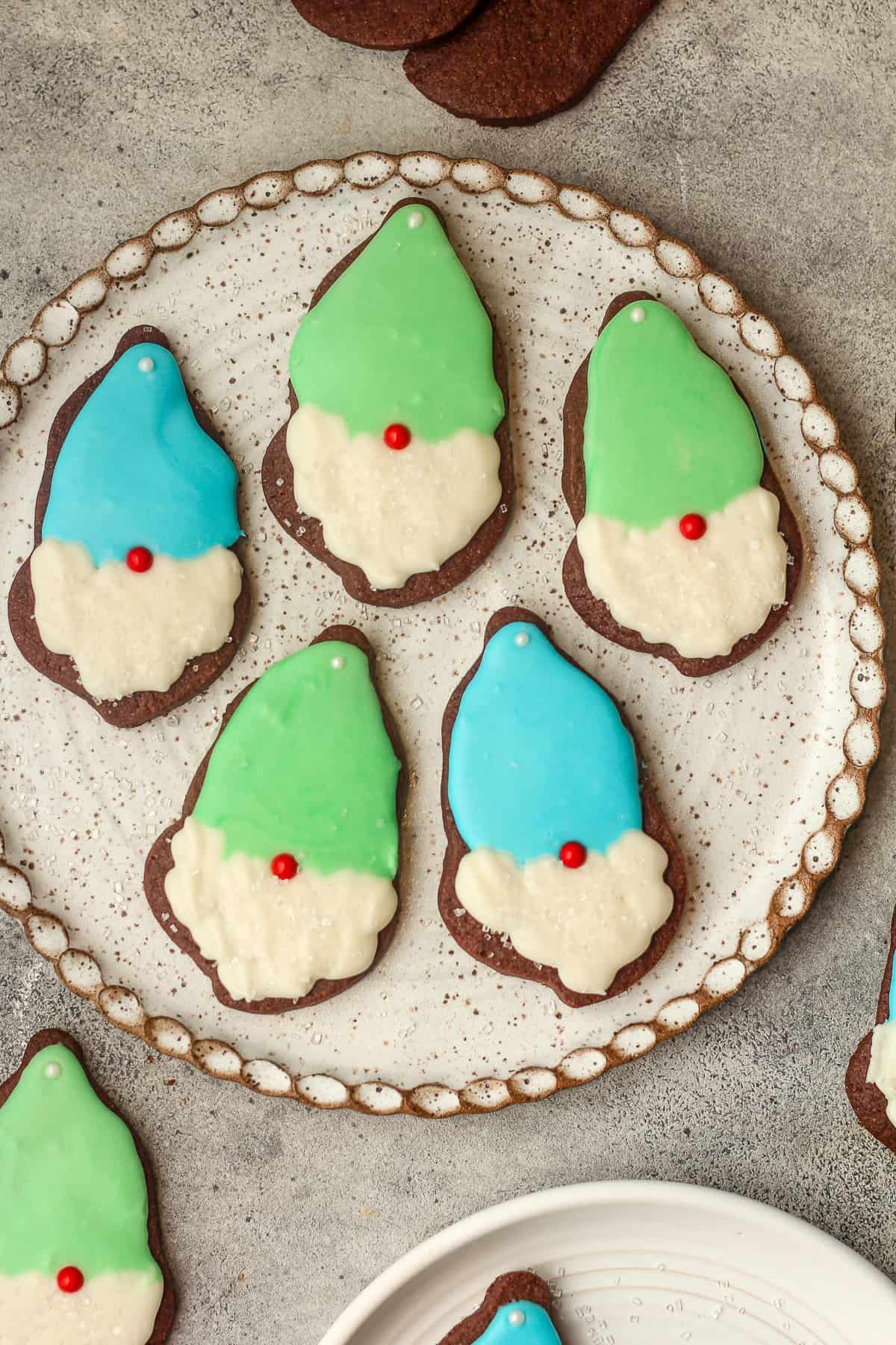 A plate of gnome cookies with green and blue hats.