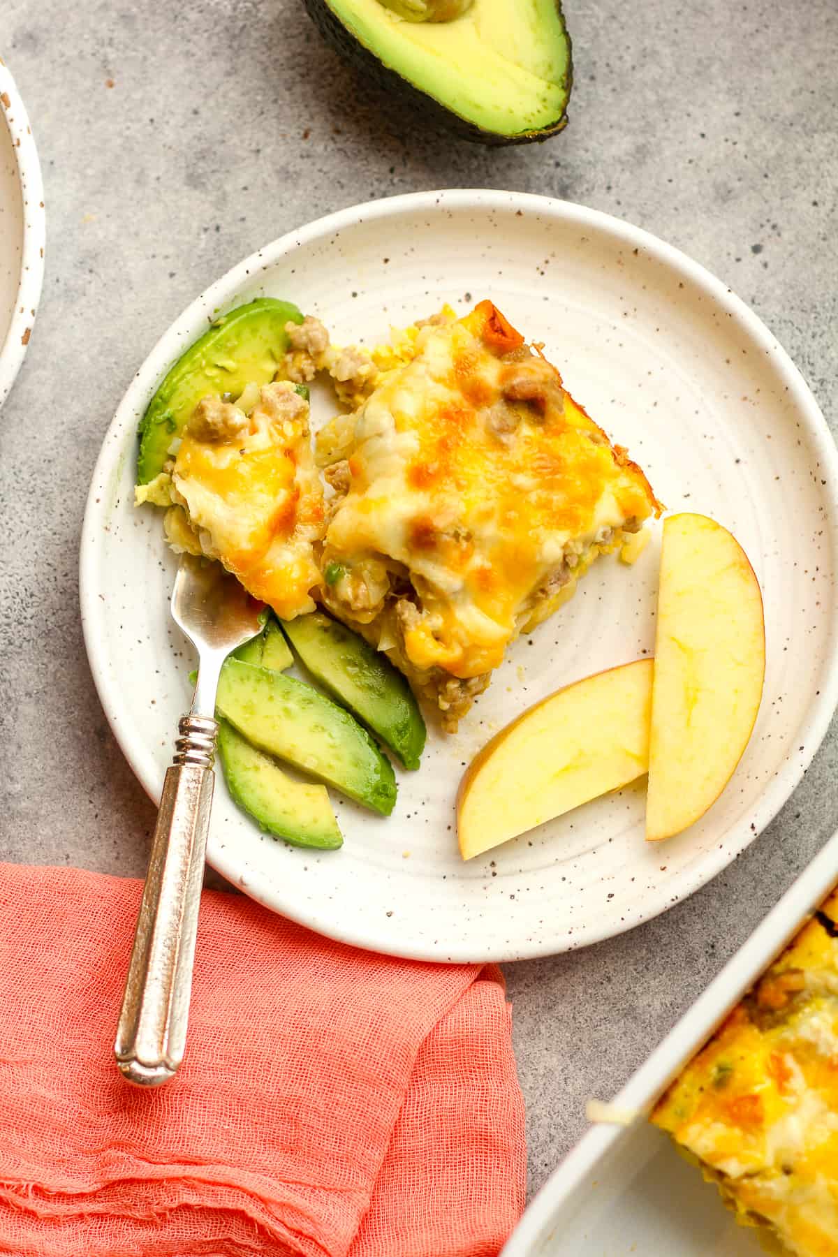 Overhead view of a piece of egg casserole with sliced avocado.