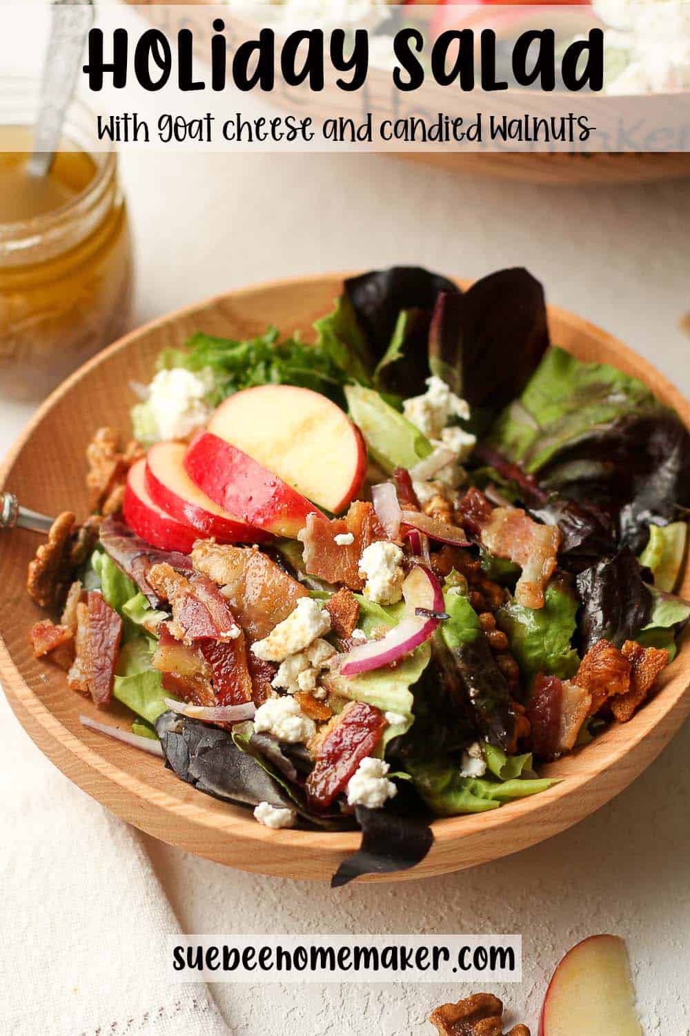 A serving of a holiday salad with goat cheese, apples, and candied walnuts.
