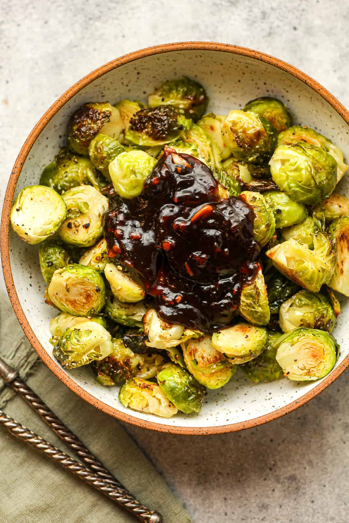 A bowl of roasted brussels sprouts with a bunch of teriyaki sauce.