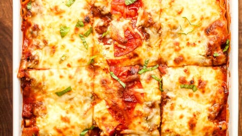 A rectangular casserole of sliced ultimate lasagna with pepperoni.