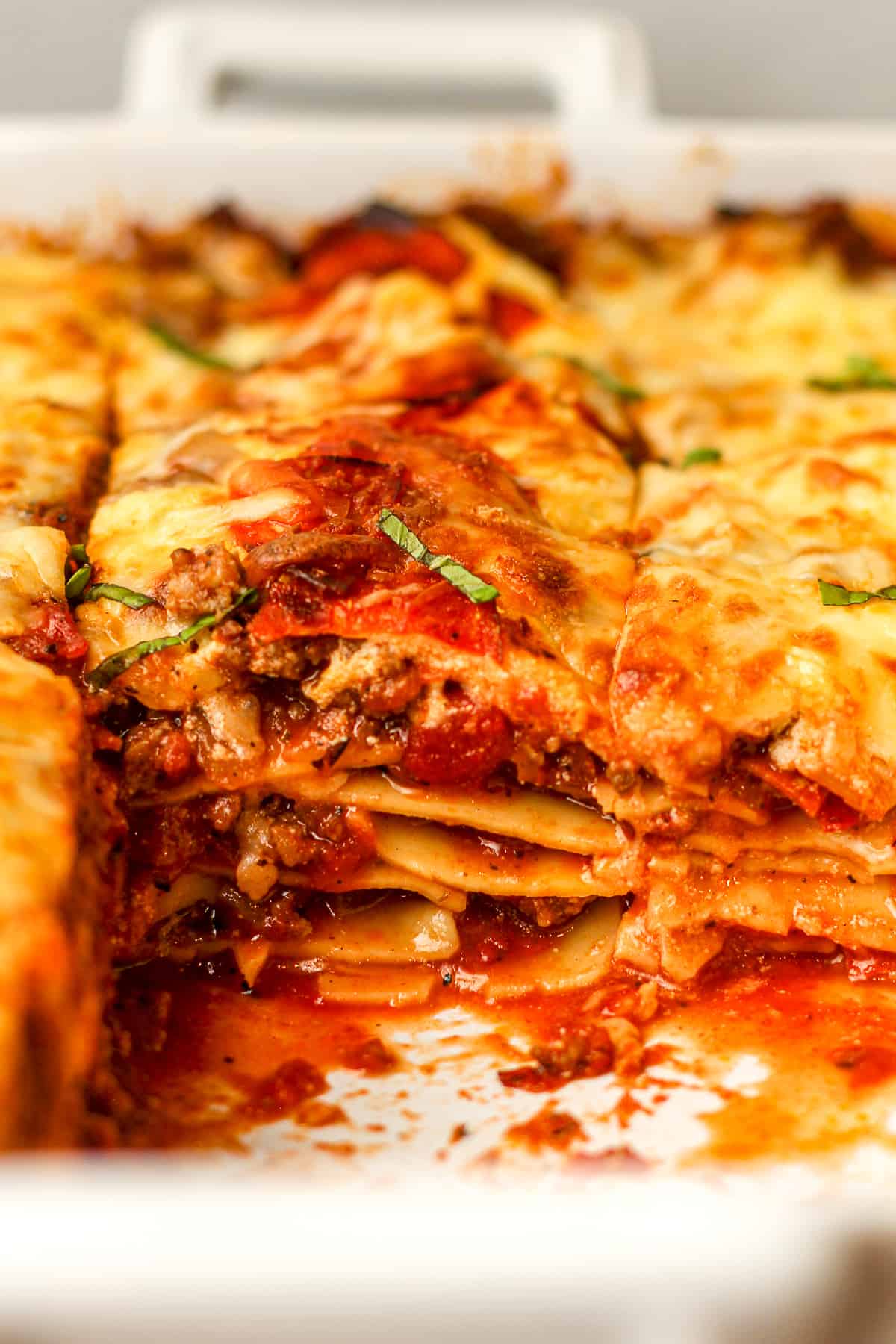 Side view of a partial pan of lasagna, showing the insides.