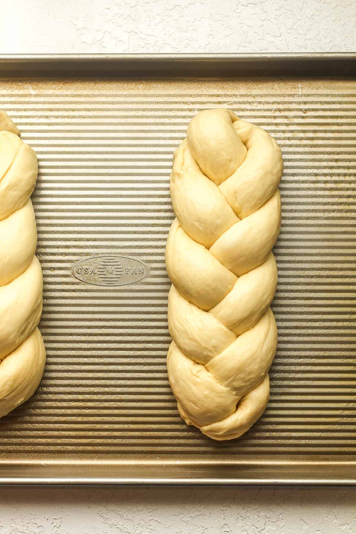 Overhead view of some braided brioche on a pan.