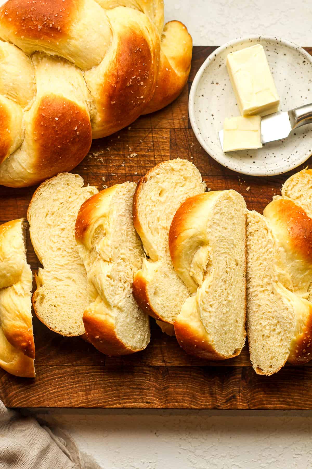 Overhead view of sliced brioche bread with a plate of butter.