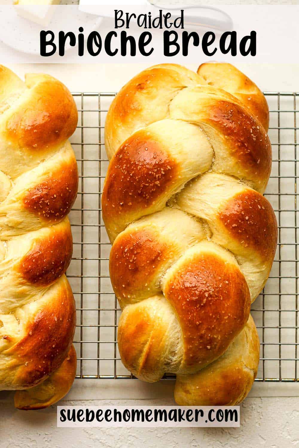 Two braided brioche loaves of bread on a wire rack.