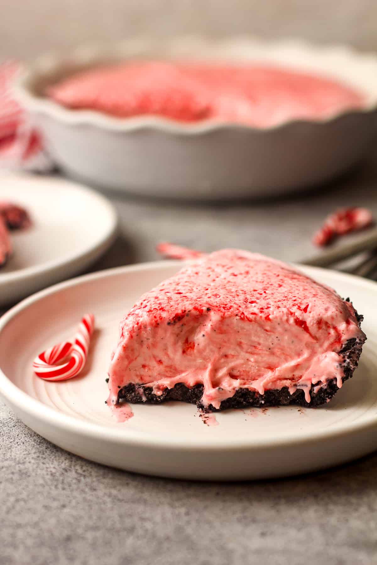 Side view of a slice of peppermint candy ice cream pie on Oreo cookie crust.