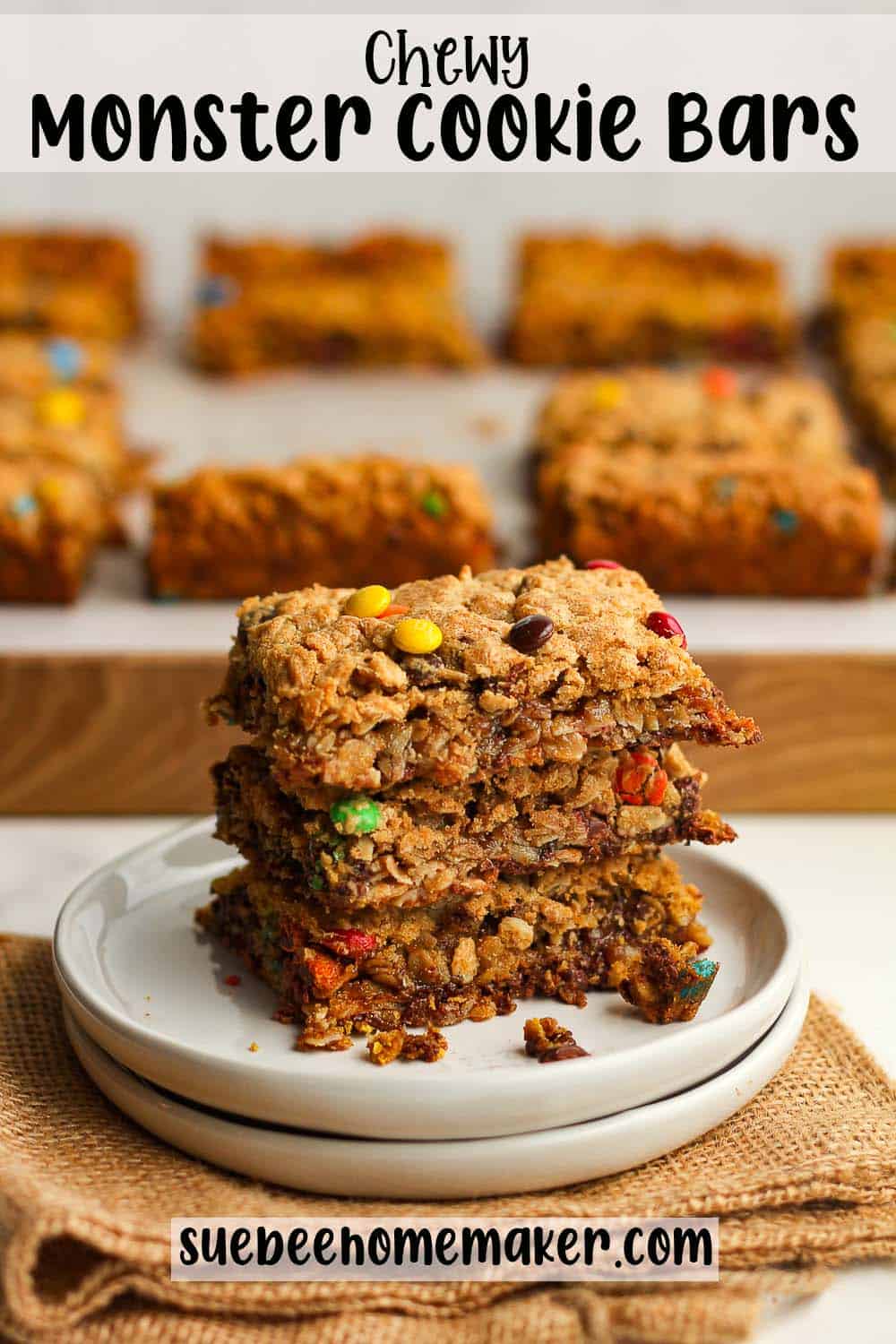 A small plate of three stacked chewy monster cookie bars.