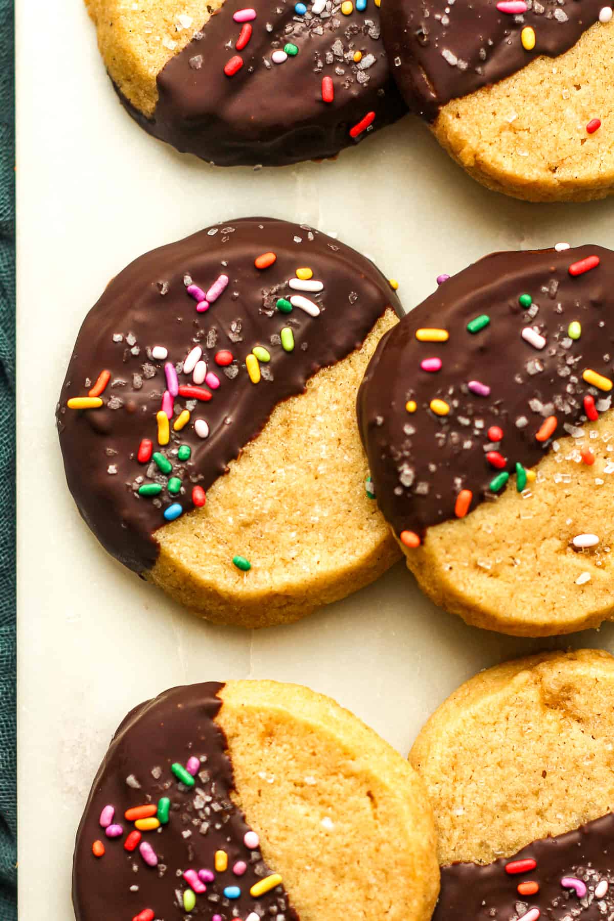 Closeup on some chocolate dipped shortbread cookies with sprinkles.