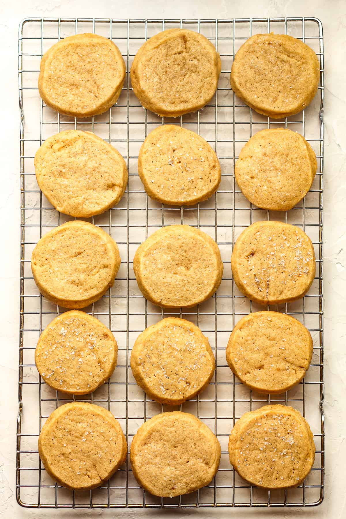 Some baked shortbread cookies on a wire cooling rack.