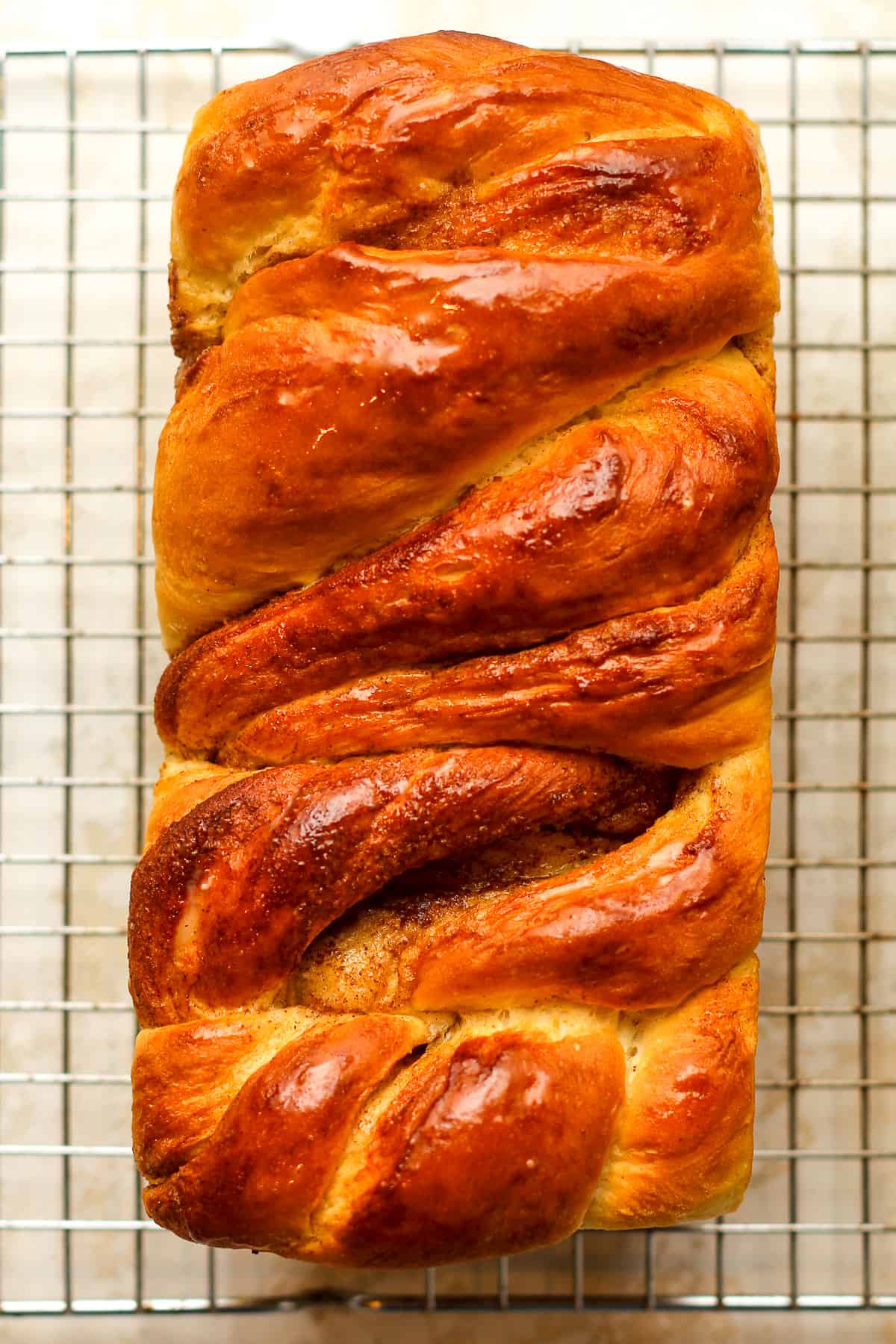 Overhead view of a loaf of cinnamon twist bread on a rack.