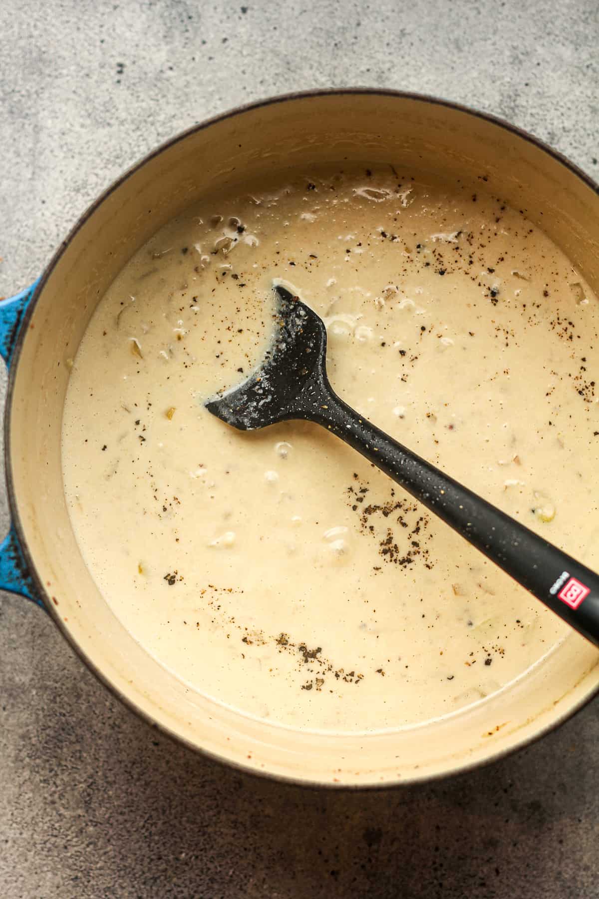 A pot of the creamy roux with a spatula.