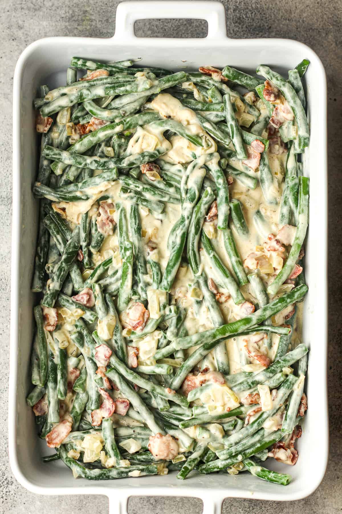 A large casserole dish of fresh green bean casserole before adding the fried onions.