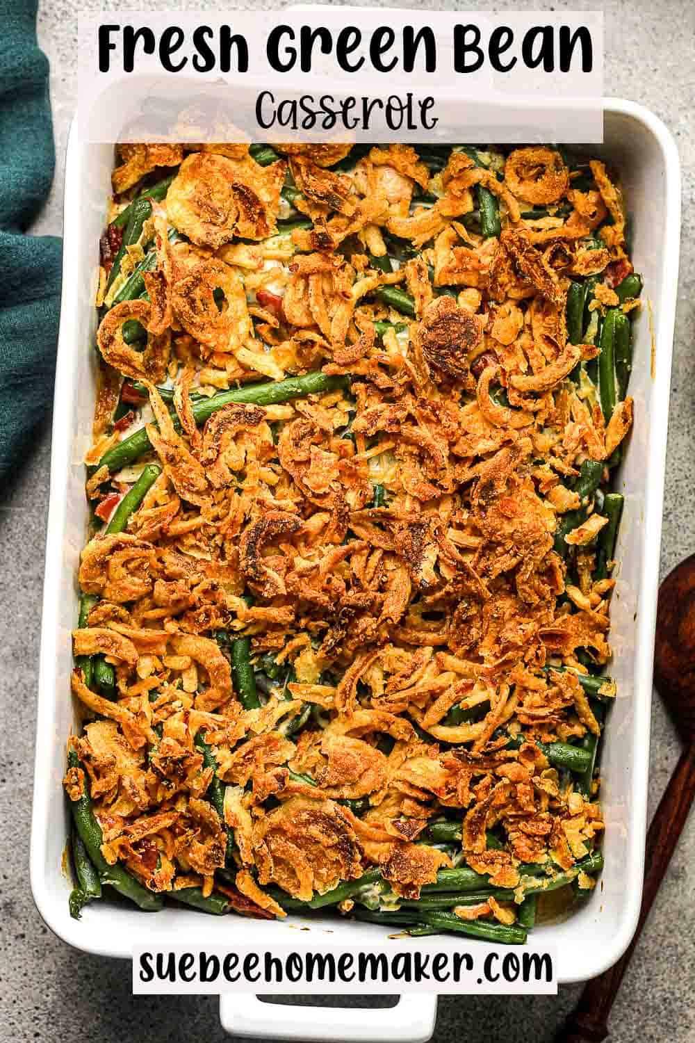 A large 9x13 pan of green bean casserole with fresh green beans.