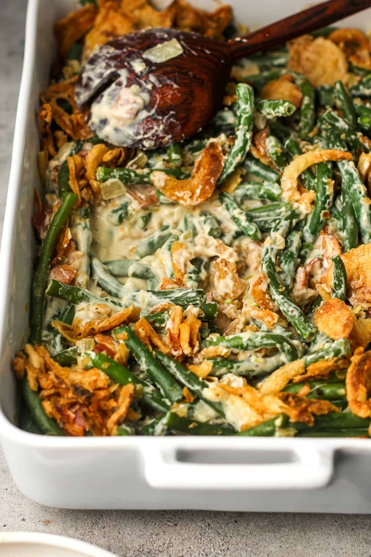 Side view of a large casserole of green bean casserole with bacon.