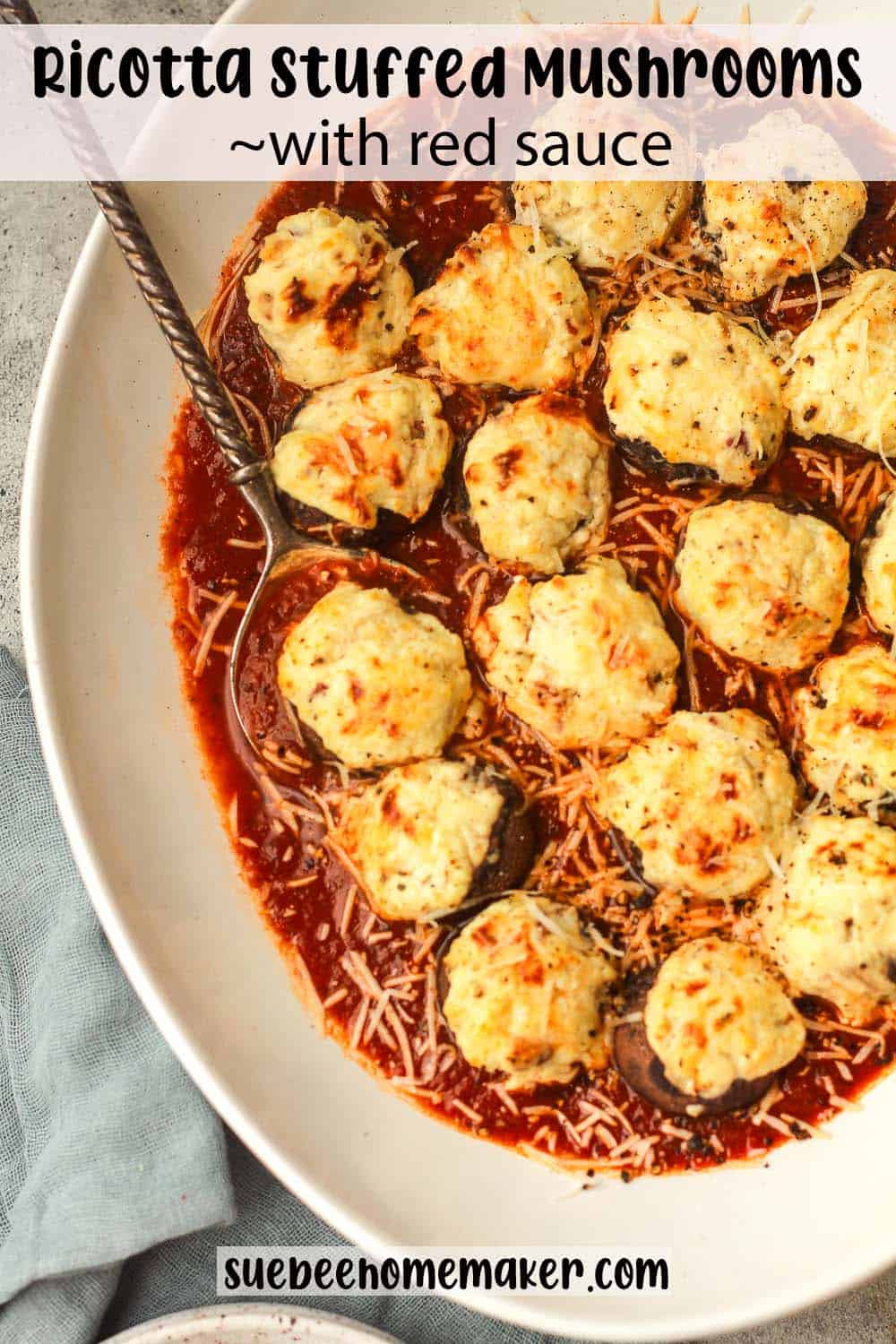 Overhead view of a platter of ricotta stuffed mushrooms over red sauce