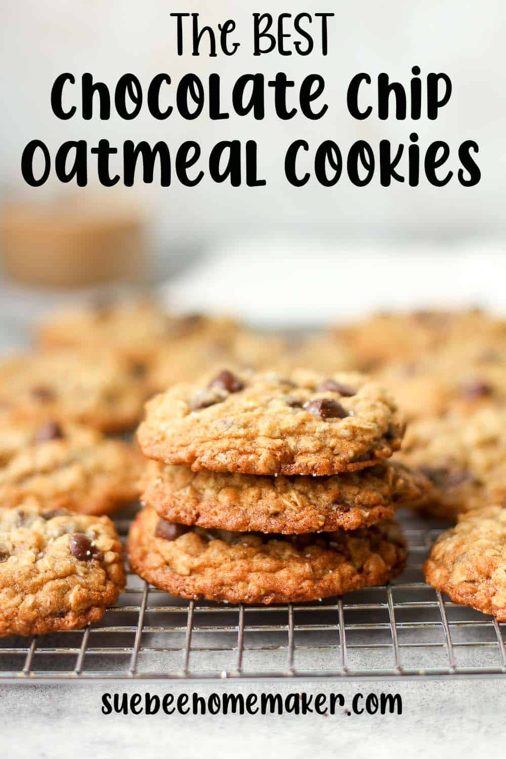 Some stacked chocolate chip oatmeal cookies on a rack.