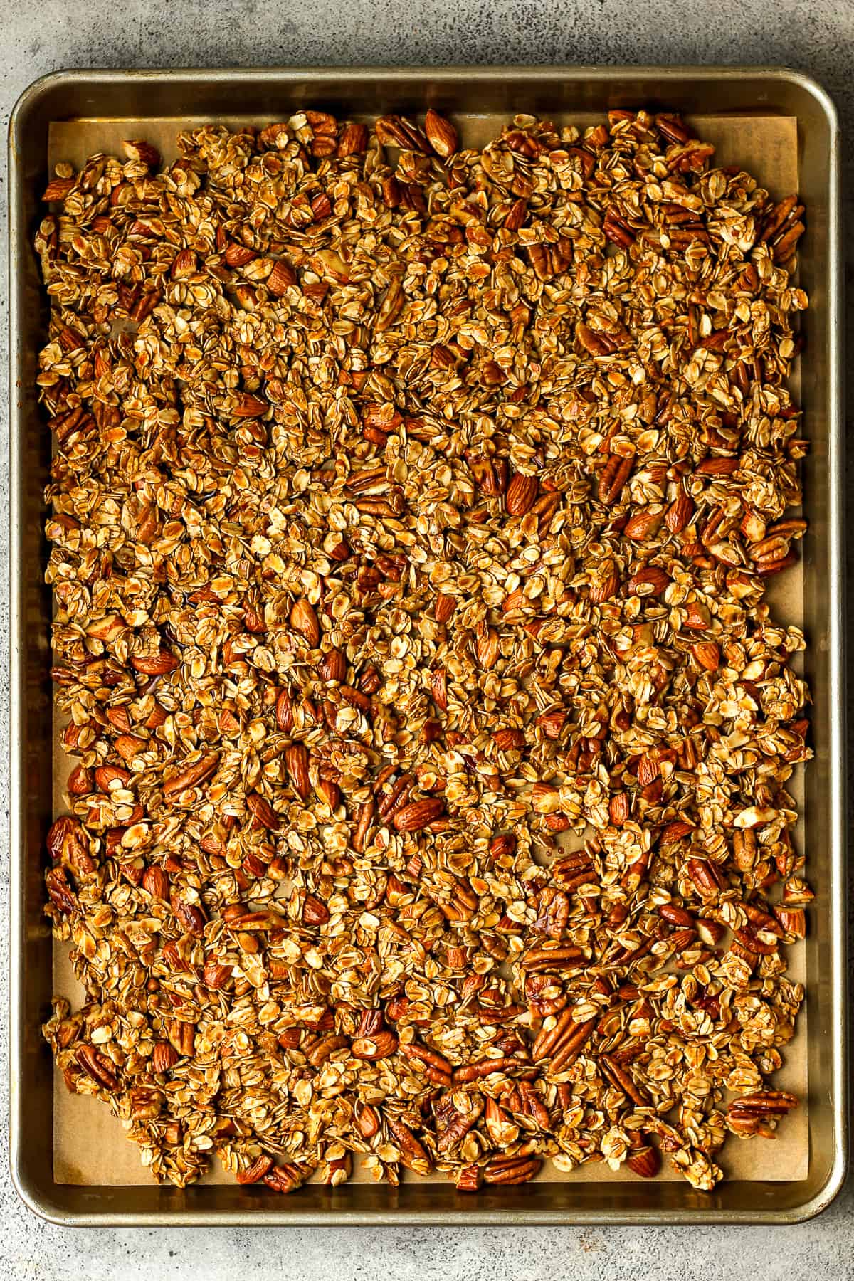 A sheet pan of wet granola mixture.