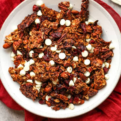 A shallow bowl of gingerbread granola with raisins.