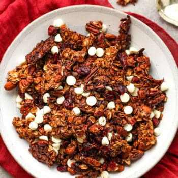 A shallow bowl of Christmas granola with white chocolate chips.