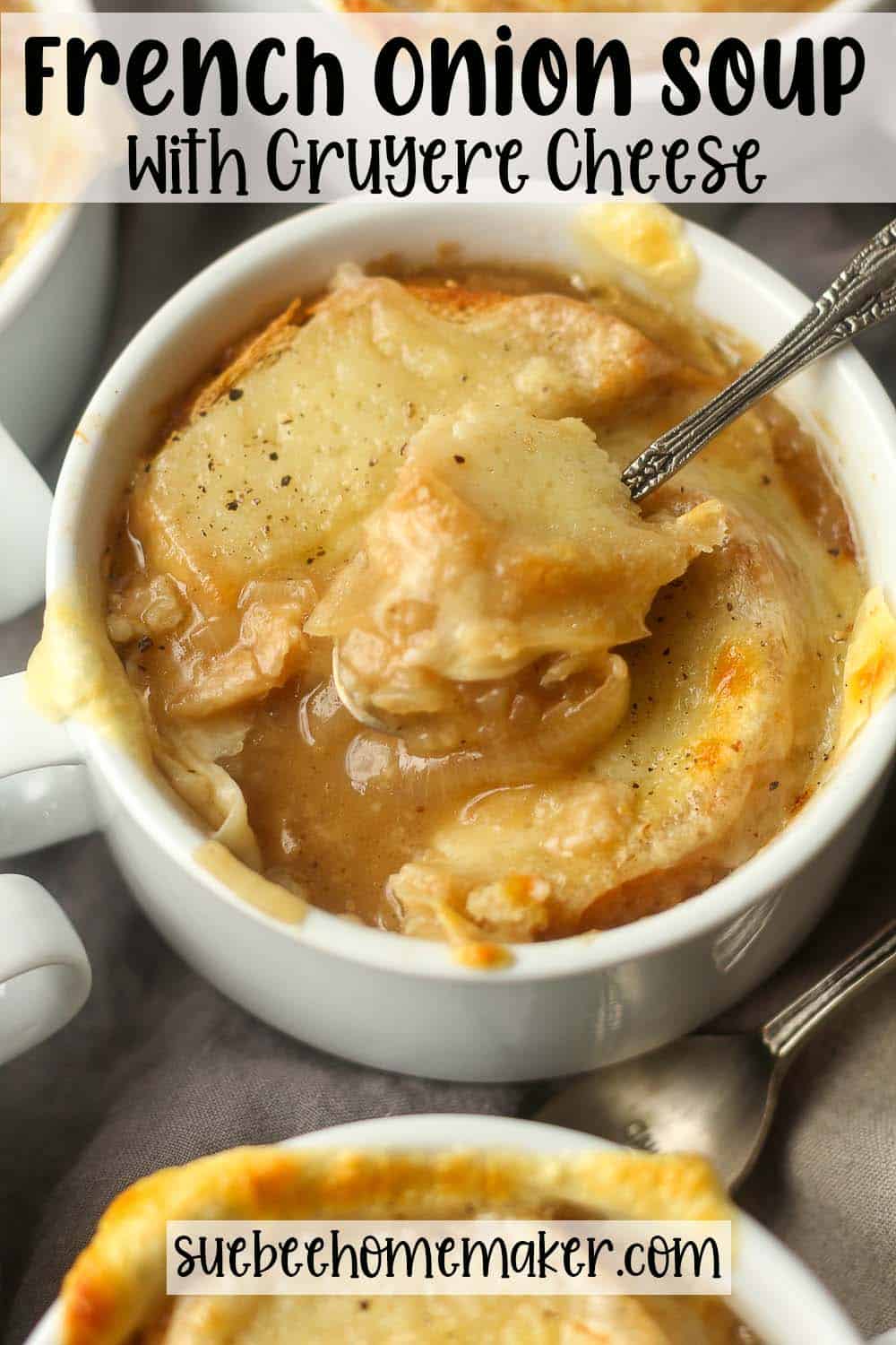 Overhead view of a bowl of French Onion Soup with a spoonful on top.