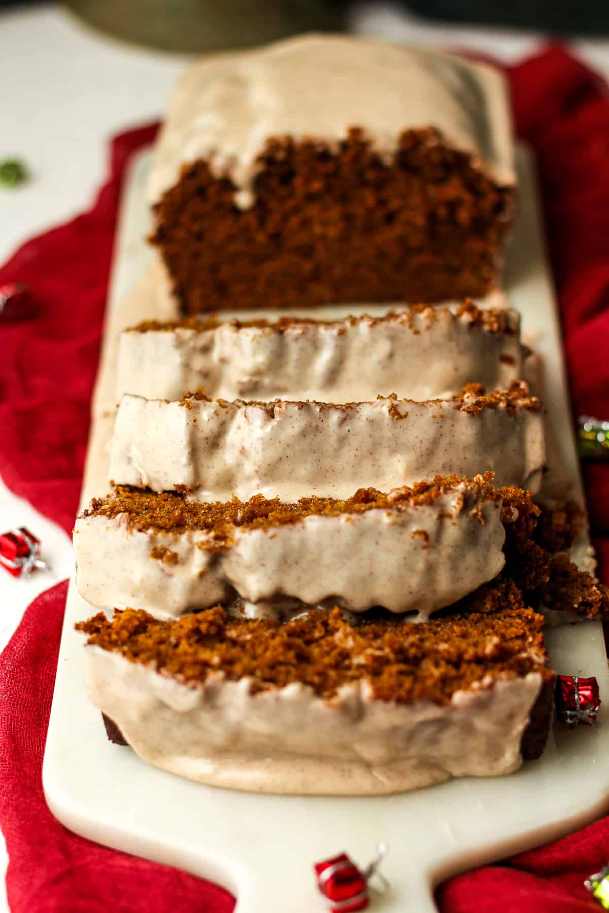 Side view of some sliced gingerbread loaf with icing.